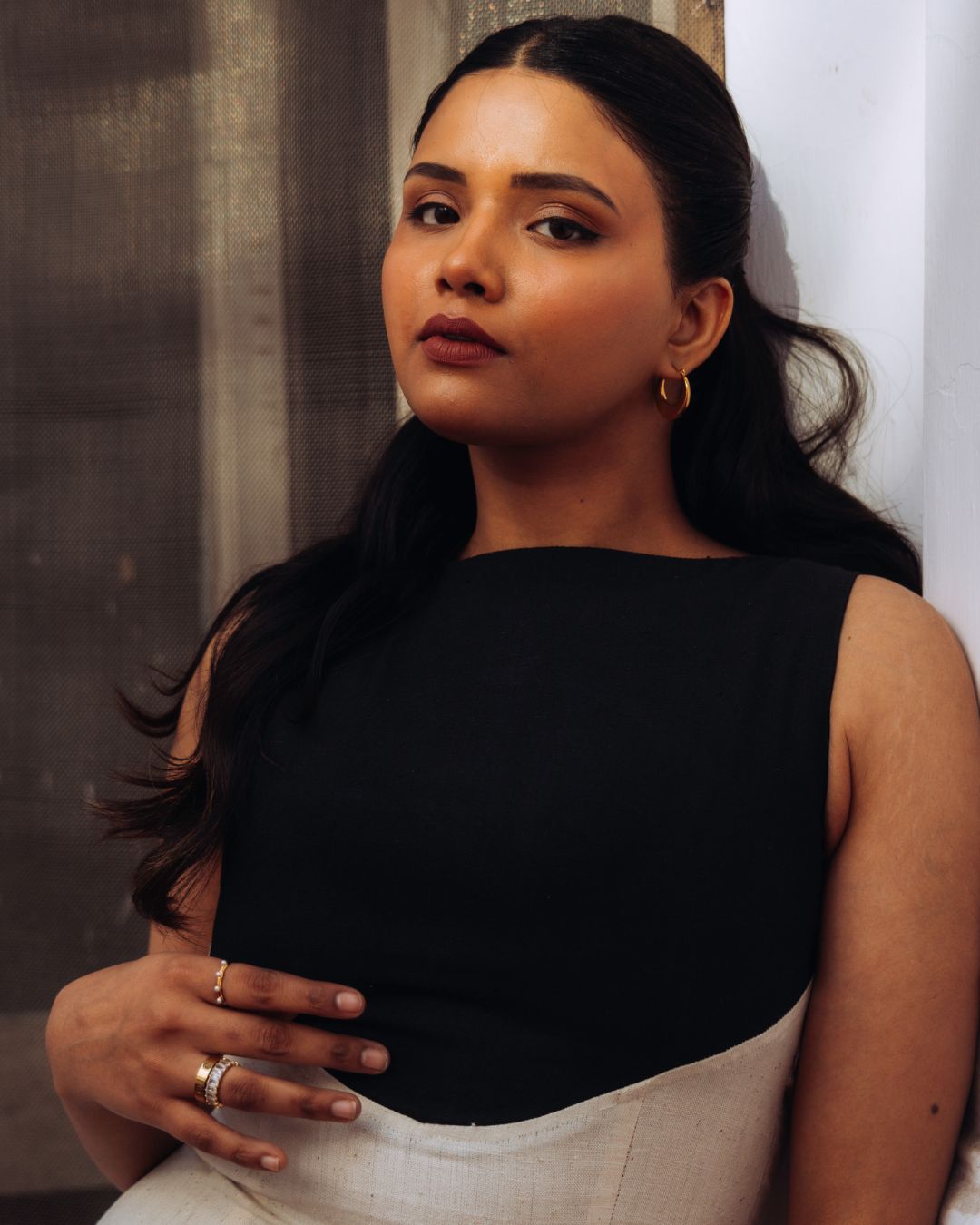 Mehvar dress Black on Ivory in Kala Cotton — Sukhanvar Sarmad SS2026. Woman wearing a black sleeveless top and white pants against a neutral background