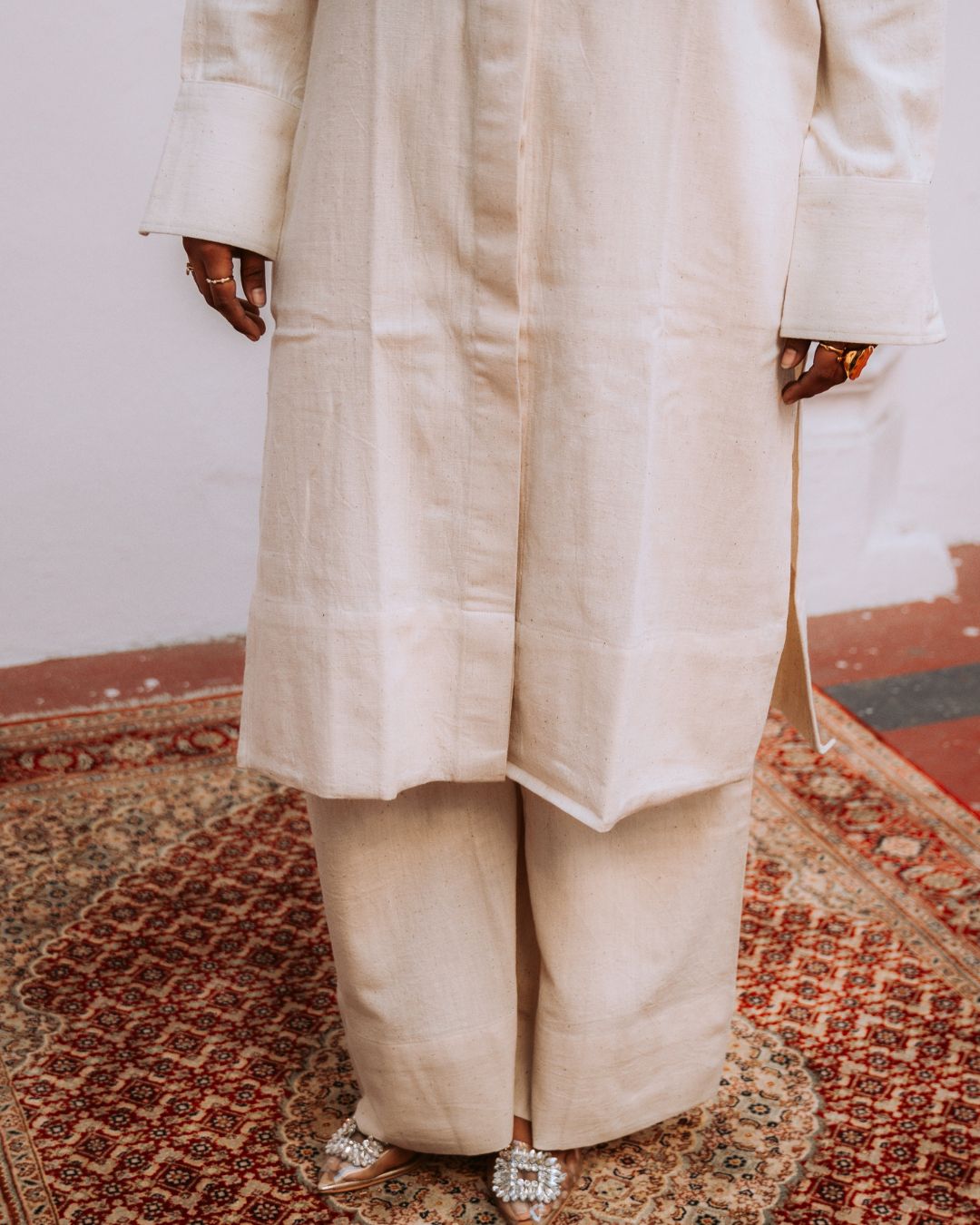 Person wearing a beige traditional outfit on a patterned rug Sarmad Clothing collection by sukhanvar Mehr Co Ord Set Kurta Pant