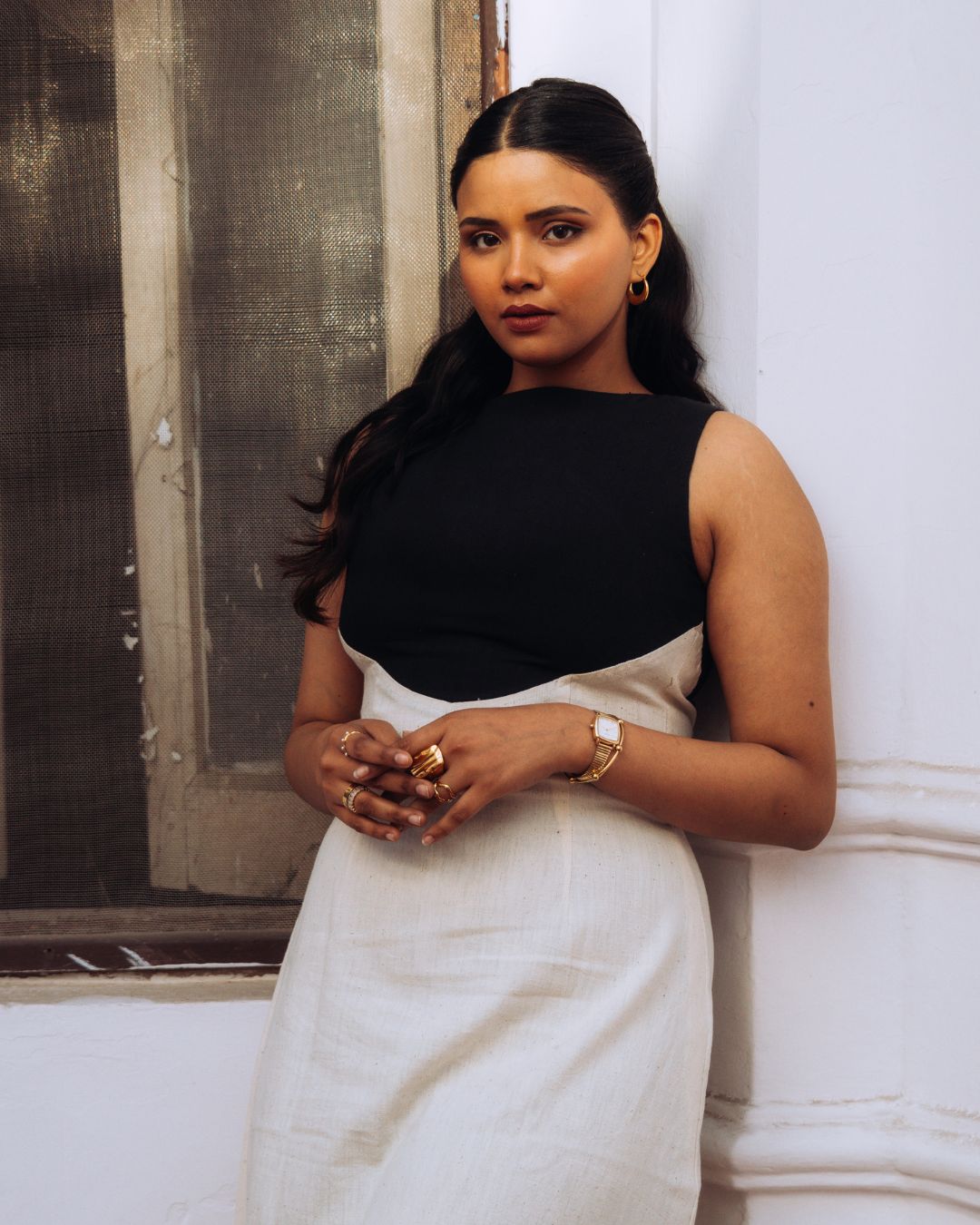 Mehvar dress Black on Ivory in Kala Cotton — Sukhanvar Sarmad SS2026. Woman in a black and white dress standing against a white wall. Sarmad Clothing collection by sukhanvar Mehvar Dress