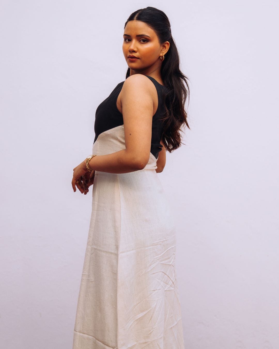 Mehvar dress Black on Ivory in Kala Cotton — Sukhanvar Sarmad SS2026. Woman wearing a black top and white skirt against a plain background 