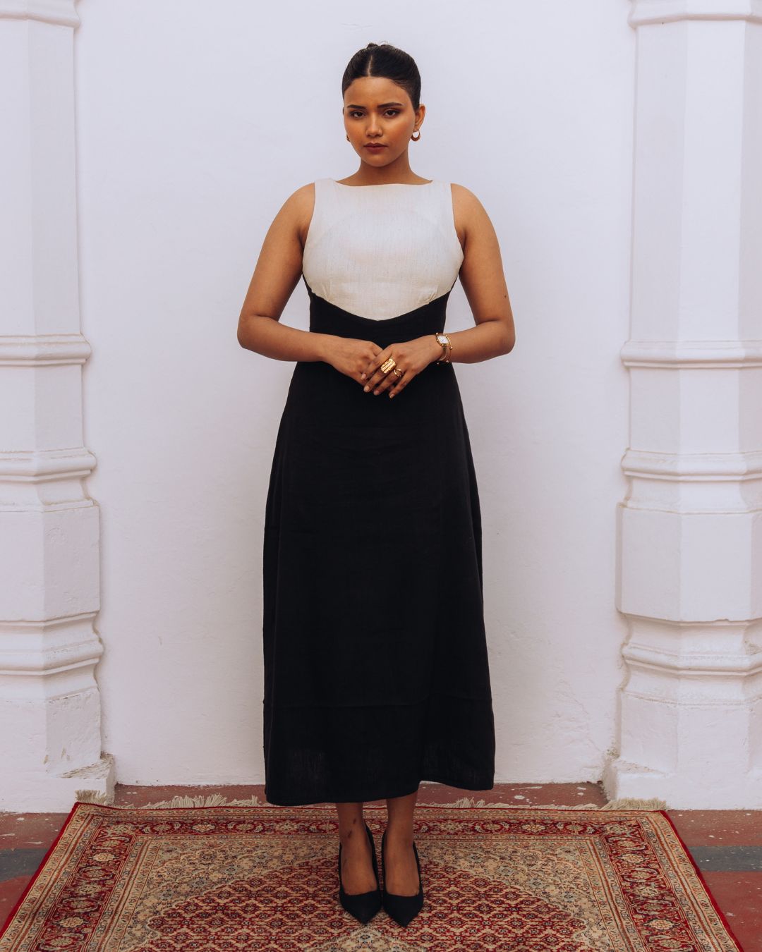 Woman wearing a black and white dress standing against a white wall. Sarmad Clothing collection by sukhanvar Mehvar Dress